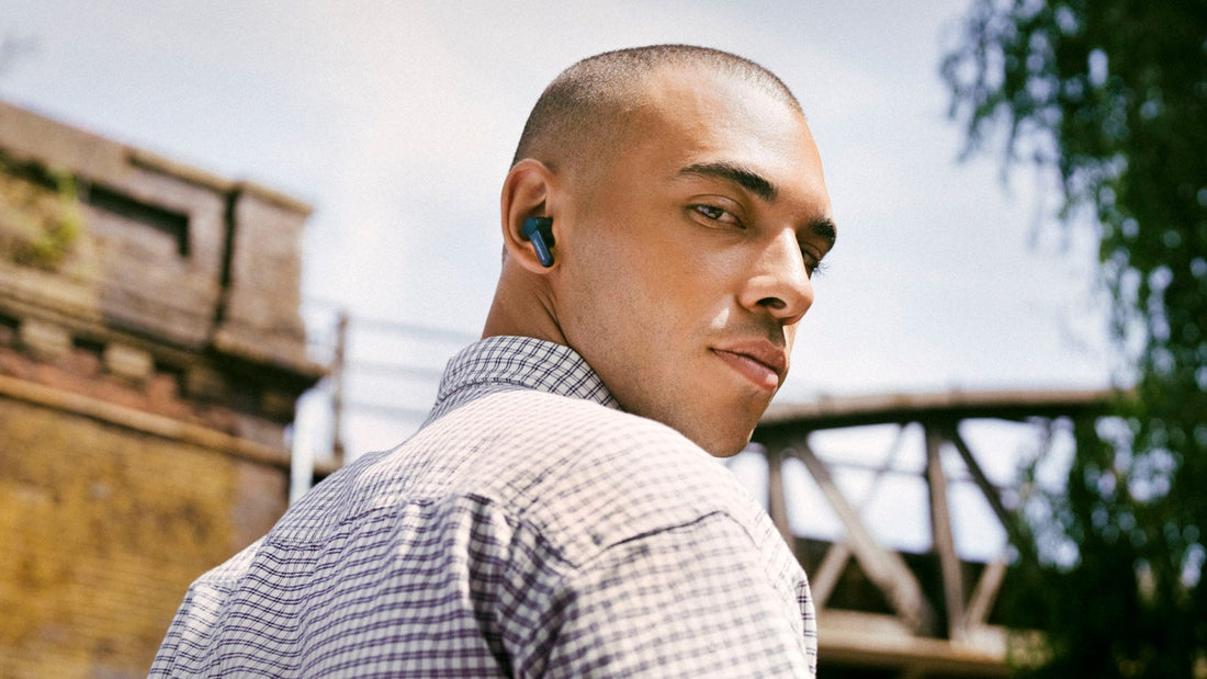 Man wearing Cambridge Audio Melomania A100 SE earbuds outdoors