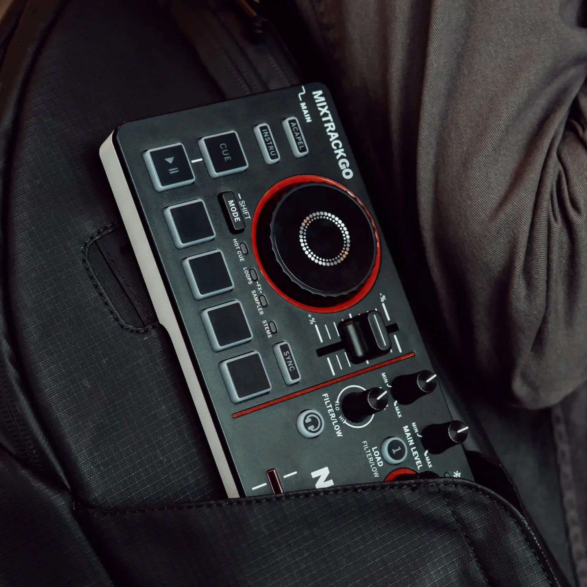 Numark Mixtrack Go tucked into a jacket pocket, showing its ultra-portable size