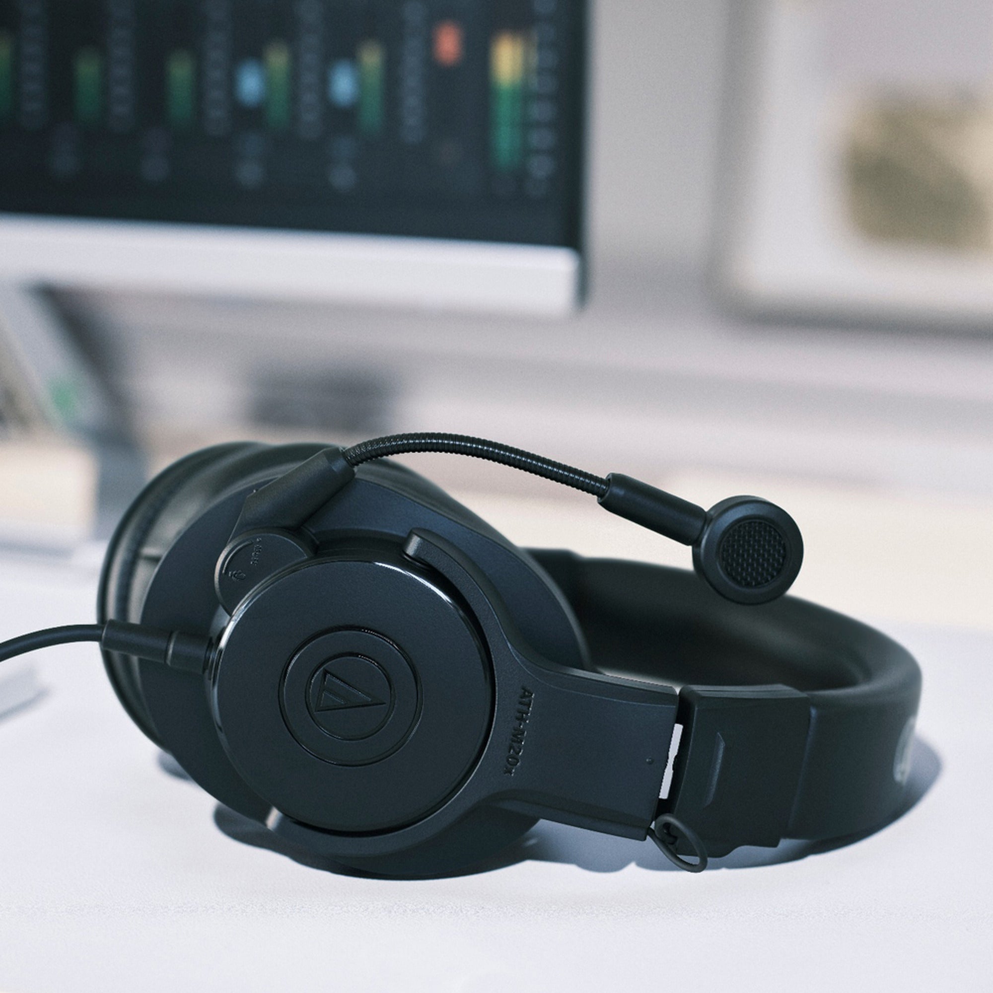 Audio-Technica ATH-M20xSTS resting on a desk beside a monitor