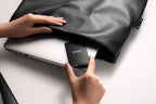 Lexar SL500 portable SSD external drive with sleek black design, shown on a wooden surface with digital devices.