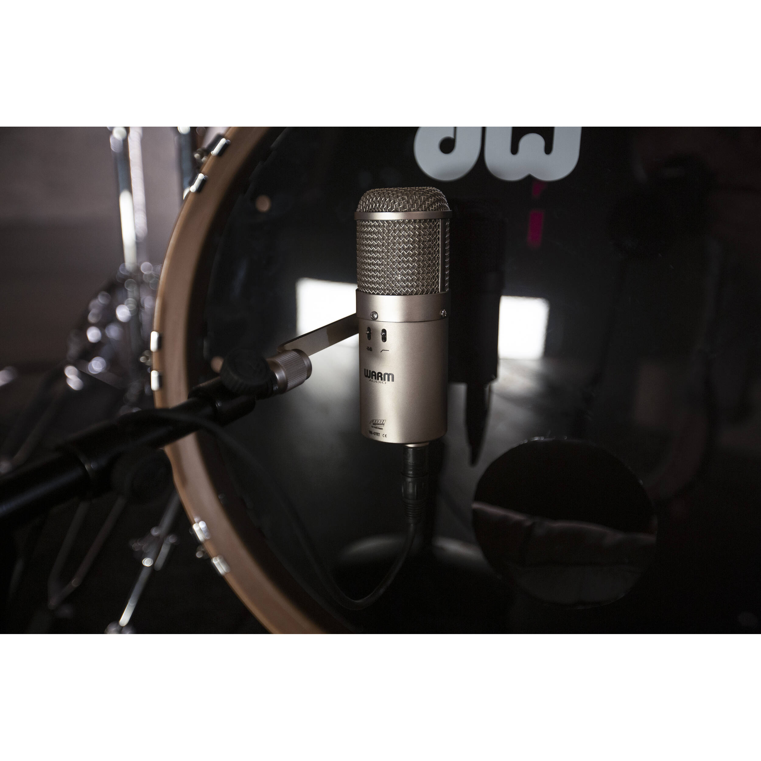 Warm Audio WA-47F condenser microphone with vintage-style grille and professional audio interface showing the microphone mounted on a stand.