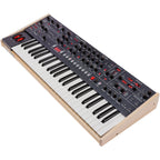 Sequential Trigon-6 synthesizer with a sleek black control panel and multiple knobs and patch points for sound shaping.