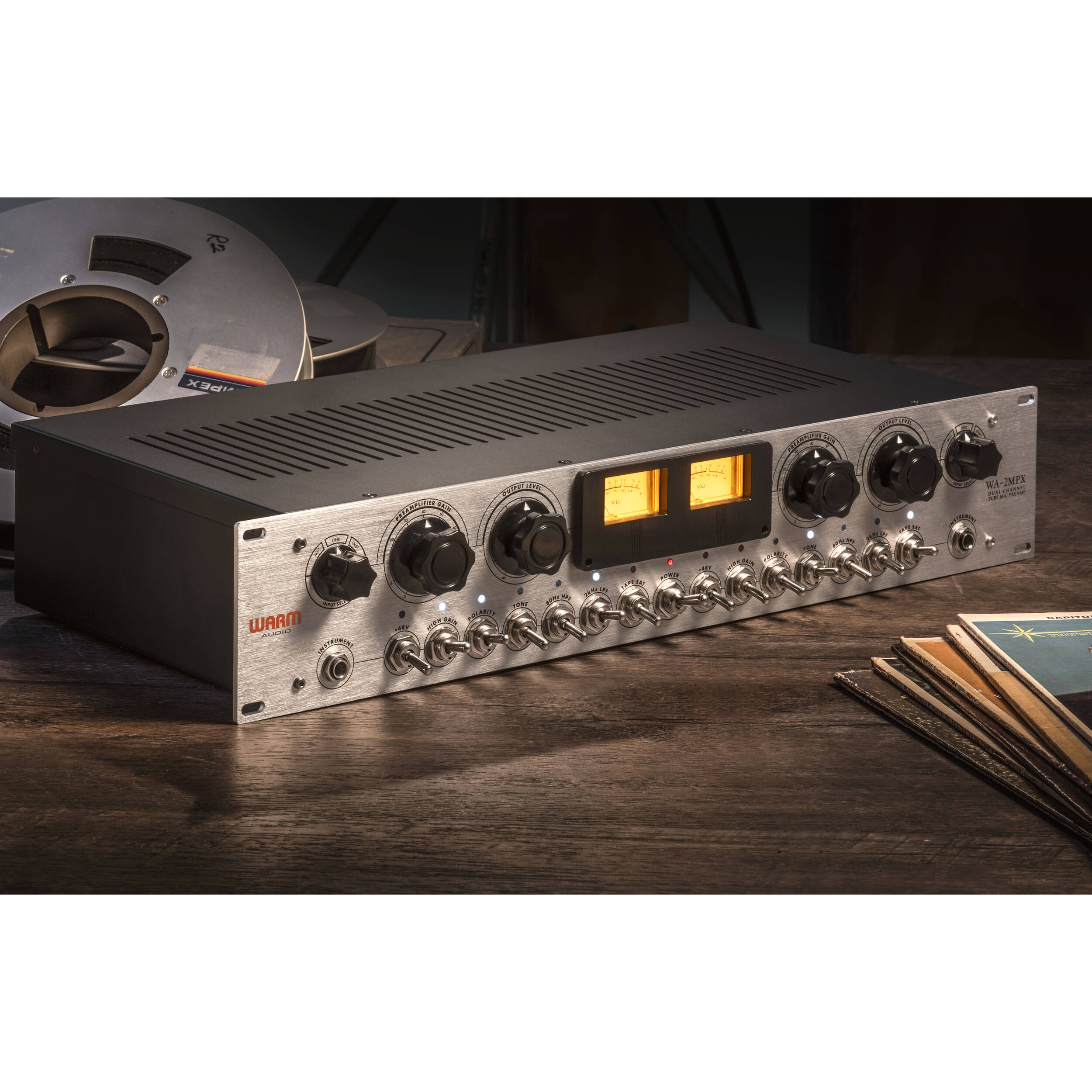 Warm Audio WA-2MPX microphone preamp with controls and input/output jacks, shown on a professional audio setup.