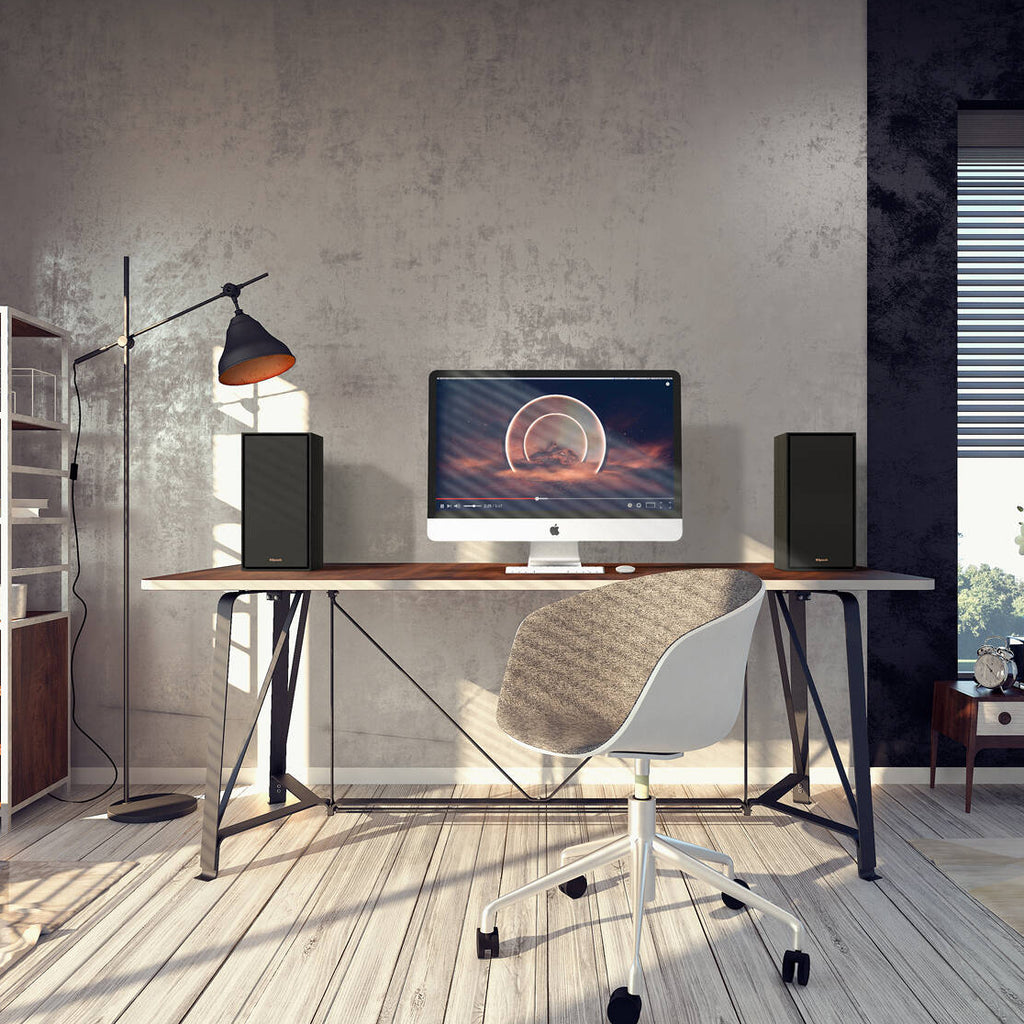 Black Klipsch R-50PM wireless speakers shown with front and side views, featuring sleek design and modern audio equipment.