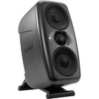 Pair of IK Multimedia iLoud MTM MK2 active nearfield monitors on a studio desk, showcasing their sleek design and front-facing speakers.