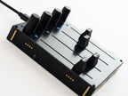 Close-up of Intech Studio EF44 Detent Series 3 MIDI controller with rotary knobs and buttons on a sleek black surface.