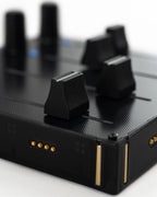 Close-up of Intech Studio EF44 Detent Series 3 MIDI controller with knobs and switches for music production.
