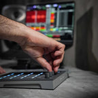 AlphaTheta SLAB MIDI controller with knobs, pads, and buttons on a sleek black surface for music production and performance.