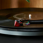 Close-up of Ortofon 2MR Red turntable cartridge showing its red body and stylus tip for high-quality vinyl playback.