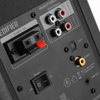 Edifier R1280DBS desktop speakers with wood finish, featuring control knobs and input ports visible on the front panel.