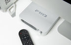 FiiO SR11 music streamer device with sleek black design and buttons on top, connected to audio cables and components.