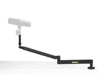 Shure SH-BROADCAST2 broadcast microphone arm mounted on a desk, adjustable arm for professional podcast or studio microphone setup.