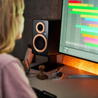 Argon Audio Forte A5 WiFi active bookshelf speakers on a wooden stand, showcasing the sleek black design and front speaker grille.