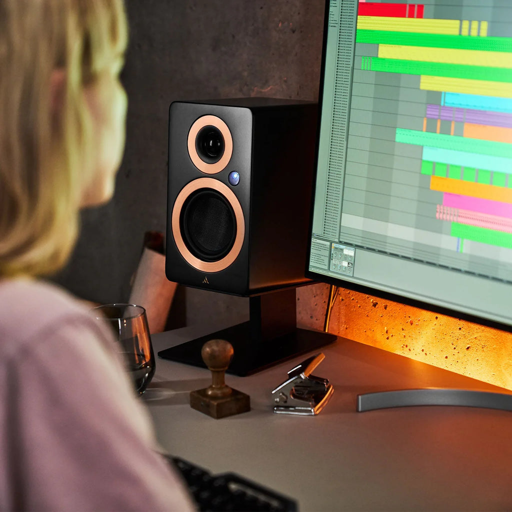 Argon Audio Forte A4 MK2 active bookshelf speakers on a black stand, showcasing their sleek design and compact size.