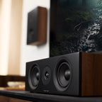 Argon Audio Forus Center speaker in white, showcasing its sleek design and front grille for home theater audio setup.