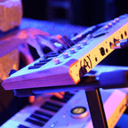 Arturia AstroLab 37 performance keyboard with black keys and compact design, featuring various control knobs and a sleek layout.