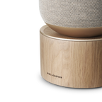 Bang & Olufsen Beosound Balance wireless speaker in natural wood finish with sleek design and control knobs visible.