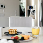 Close-up of Bluesound Pulse 2i wireless speaker in white, showing its sleek front design and control buttons.