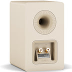 DALI Kupid passive bookshelf speakers with caramel white grill, showcasing their sleek compact design and modern aesthetic.