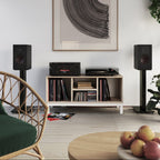 Black DALI Opticon 2 MK2 passive bookshelf speakers with sleek design and wood finish, showing the front grille and speaker cones.