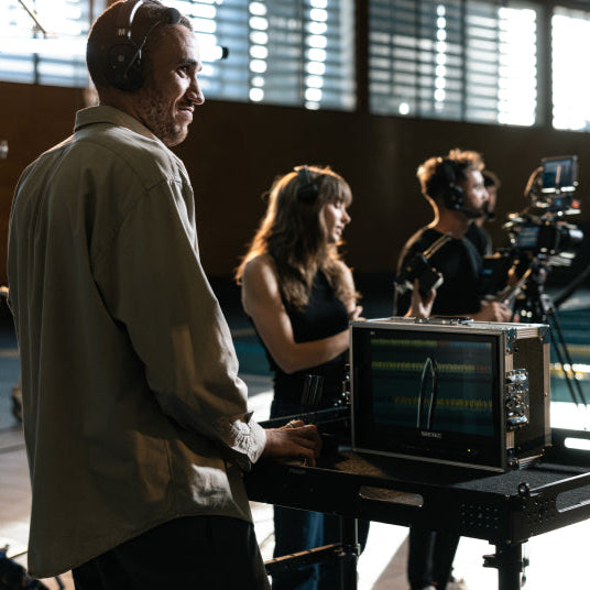 Hollyland Solidcom SE Pro remote headset for professional video communication, shown in a group setting with multiple headsets.