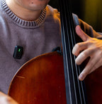 Instamic Pro Plus C Mono portable recorder with musician in background, compact black device for high-quality audio recording.