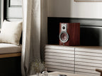 DALI Rubikore 2 passive bookshelf speakers shown in a modern home setting with sleek black cabinets and detailed speaker drivers.
