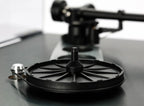 Close-up of Rega Planar 3 RS turntable with aluminum platter and Nd5 cartridge, showing the hub bearing and tonearm details.