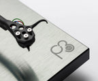 Close-up of Rega Planar 3 RS turntable with aluminum plinth and Nd5 cartridge, showing the tonearm and platter details.