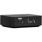 Rode AI-1 audio interface shown from a three-quarter left back angle, featuring input and output ports on a sleek black device.