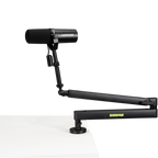 Shure SH-BROADCAST2 broadcast microphone arm mounted on a desk with adjustable joints and cable management system.