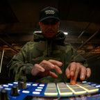 Akai Professional MPC One G2 played in a studio, glowing pads in low light