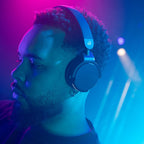AlphaTheta HDJ-F9 worn by a DJ under club lights