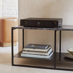 Arcam A25+ stereo amplifier showing front panel with control knobs and display, black finish, compact design, Arcam branding visible.
