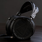 Audeze LCD-X Creator Package studio headphones with leather-free ear cups, featuring a sleek black design and open-back ear cups.