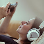 Woman playing on a handheld console with the Beyerdynamic MMX 130 Wireless headset on