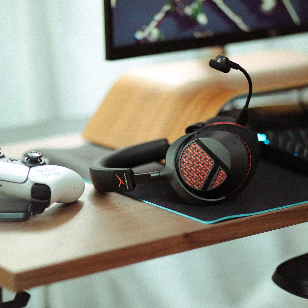 Beyerdynamic MMX 130 Wireless headset resting on a desk next to a game controller