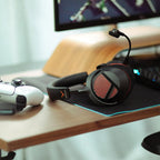 Beyerdynamic MMX 130 Wireless headset resting on a desk next to a game controller