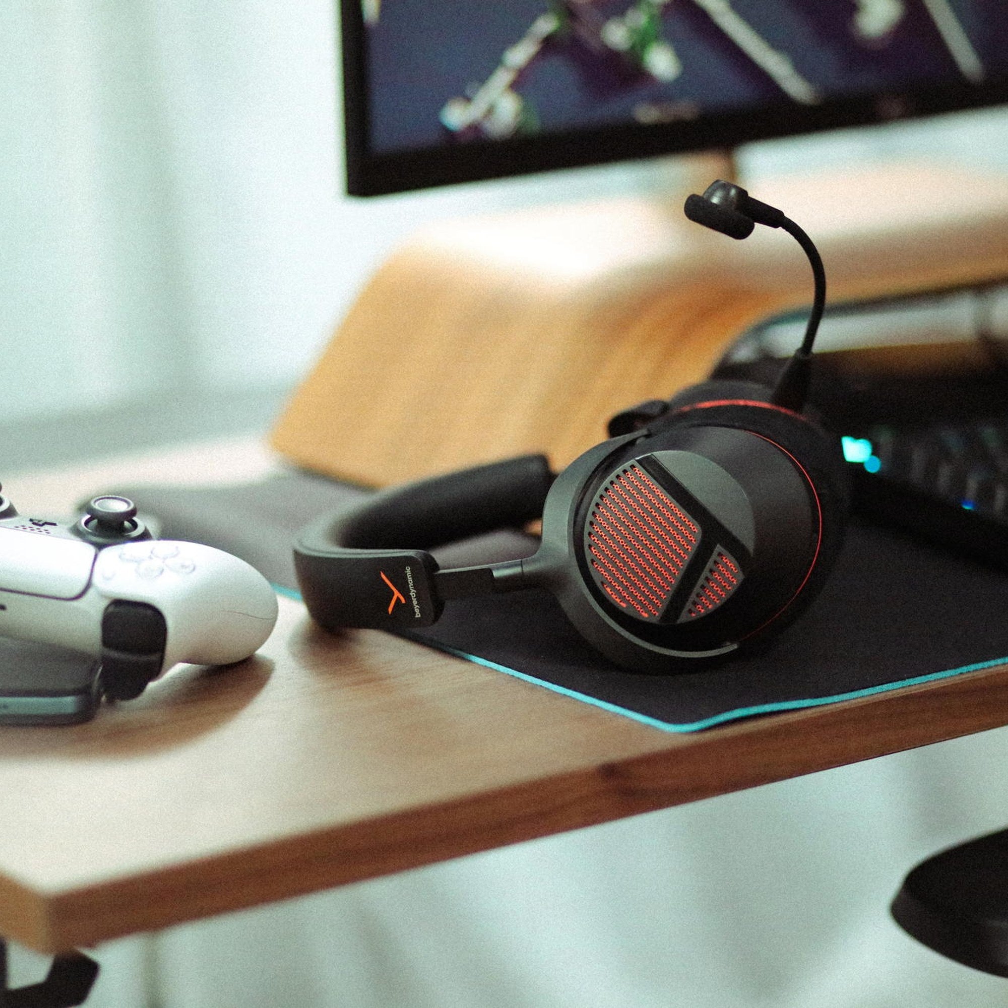 Beyerdynamic MMX 130 Wireless headset resting on a desk next to a game controller