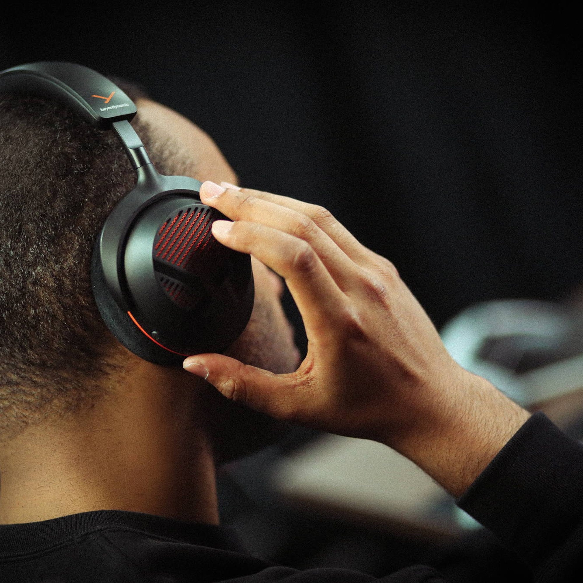 Gamer adjusting the Beyerdynamic MMX 130 Wireless headset in a gaming room