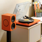 Cambridge Audio Spira turntable in Orange with an orange L/R speaker on a stand