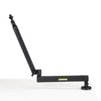 Shure SH-BROADCAST2 broadcast microphone arm mounted on a desk, adjustable boom arm for professional audio recording setups.