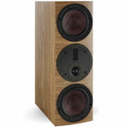 DALI Rubikore Cinema center speaker with natural walnut finish, showcasing its sleek design and front grille for home theater setup.