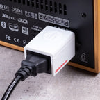 iFi Audio GND Defender connected to audio equipment, showcasing its compact design and utility in reducing noise interference.