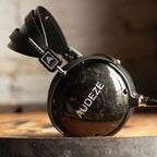 Audeze LCD-2 Classic closed-back leather-free Head-fi headphones with black ear cups and headband, showing sleek design and ear cushions.