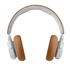 Bang & Olufsen Beoplay HX wireless headphones with timber-colored ear cups and sleek design, shown from the side.