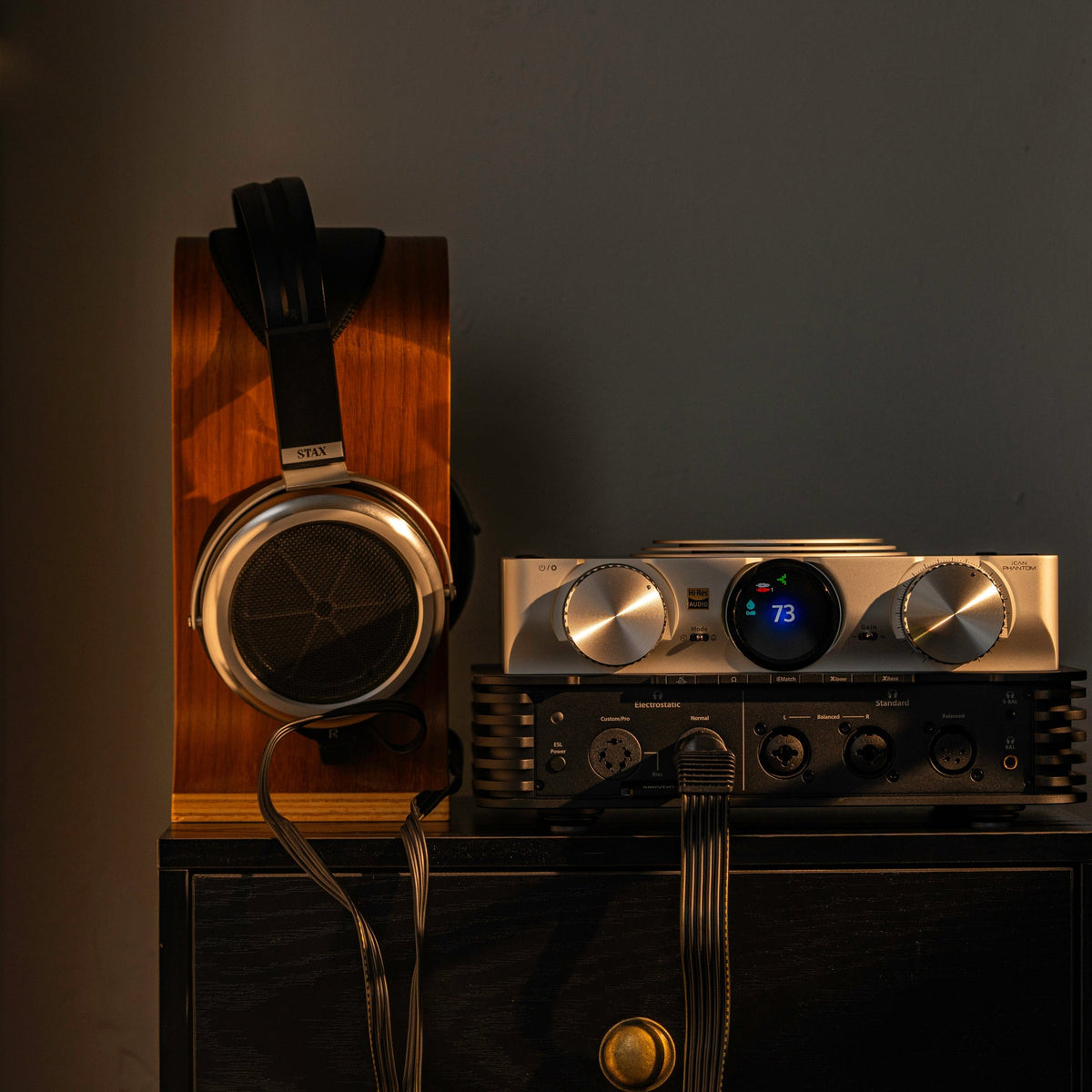 iFi Audio iCAN Phantom 1.5 headphone amplifier with electrostatic headphones on a wooden stand