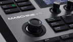 Native Instruments Maschine+ drum machine and sampler with grid controller, buttons, and touchscreen display.