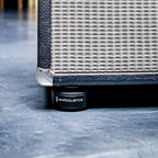 IsoAcoustics ISO-Puck studio monitor stands on a surface, designed to isolate and reduce vibrations for guitar and bass amps.