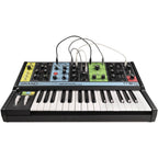 Moog Grandmother synthesizer with wooden sides and control knobs, showing its front panel and patch bay in a studio setting.
